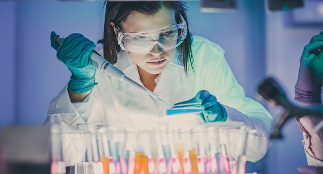 Young attractive female scientist holding a red transparent pill with futuristic scientific air interface with chemical formulas and research data in the foreground