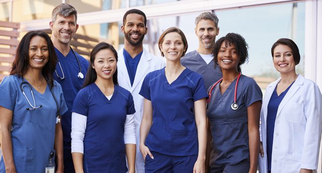 Smiling medical team standing together outside a hospital